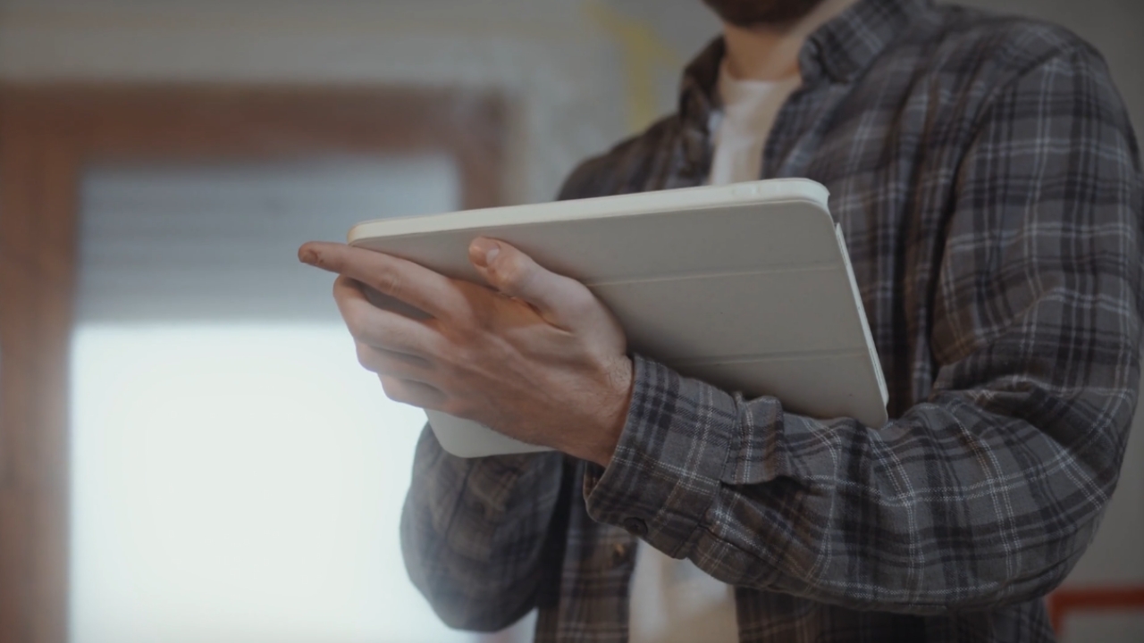 A homeowner checks project details on a tablet.