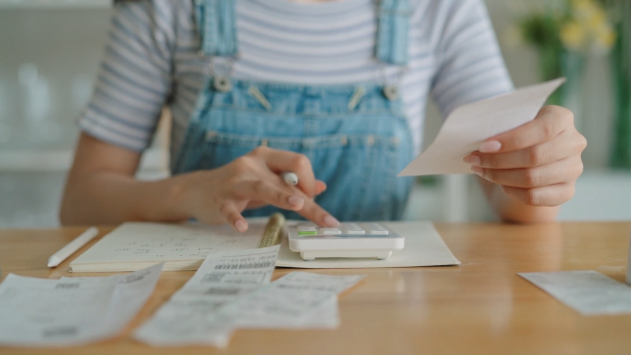A homeowner uses a calculator to review expenses and receipts.
