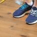 A person tests a hardwood floor for squeaks by stepping on loose boards.