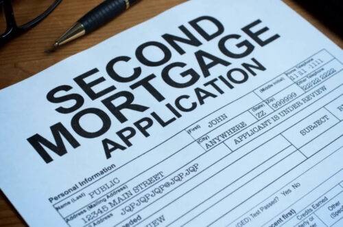 A second mortgage application form sits on a wooden desk beside a pen and glasses.