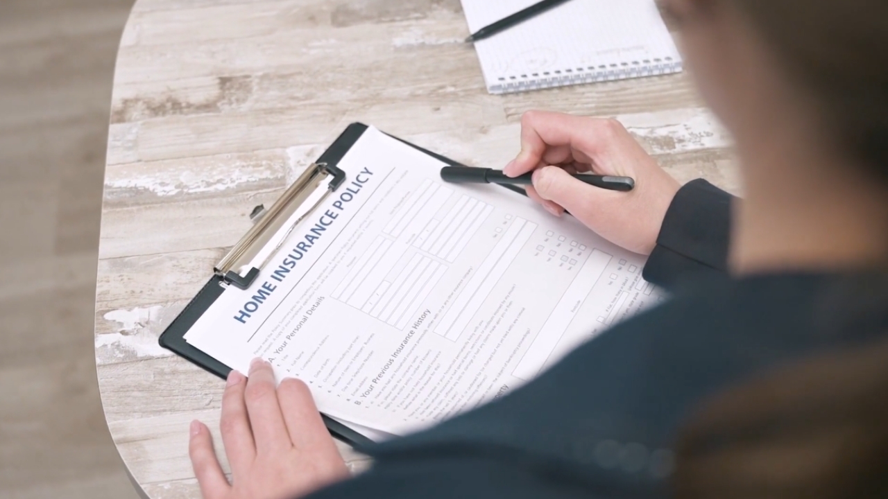 A person reviews a home insurance policy form at a table.