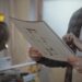 Homeowners review renovation plans beside a miter saw.