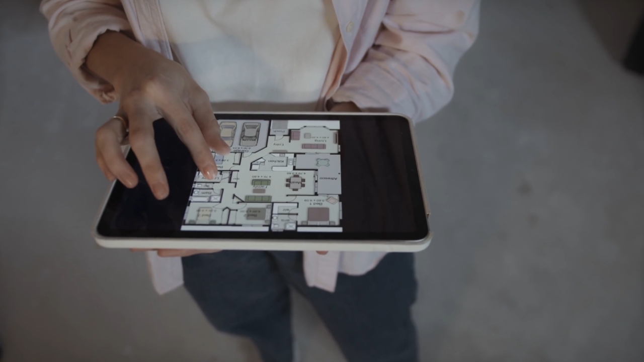 A homeowner reviews a floor plan on a tablet.